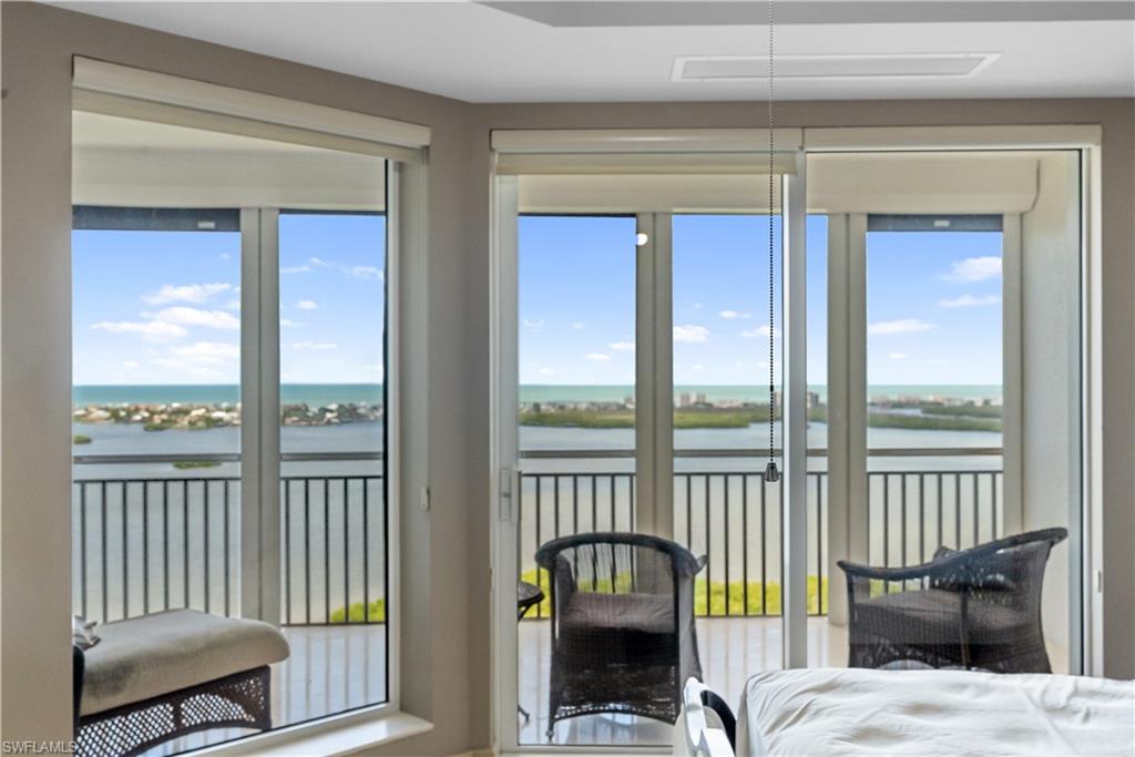 Sliding glass doors opening to a balcony with black railings, offering a waterscape