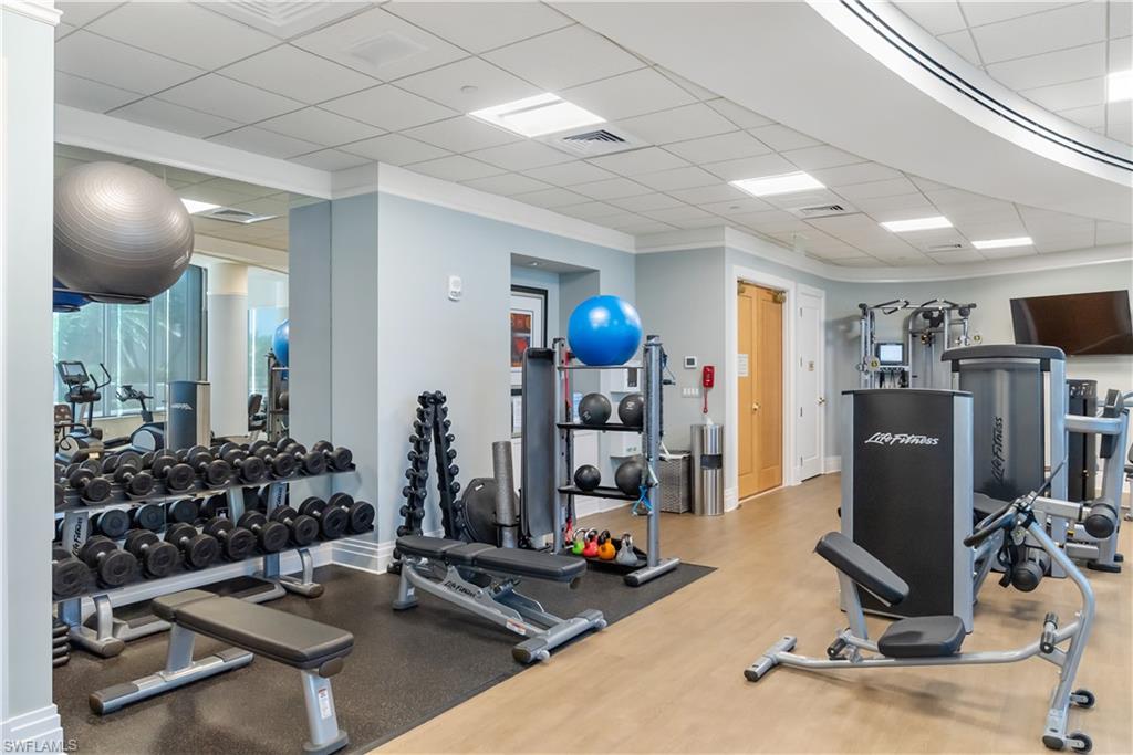 Fitness area featuring wood-finish flooring, recessed lighting, and a mirrored wall
