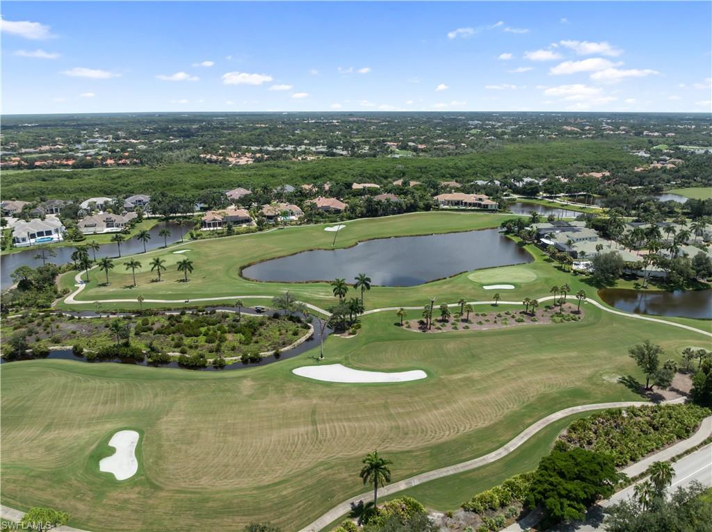 Expansive golf course with multiple greens and sand traps, surrounded by water features and established landscaping