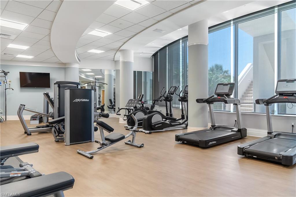 Fitness center with wood-finish flooring, recessed lighting, and expansive windows