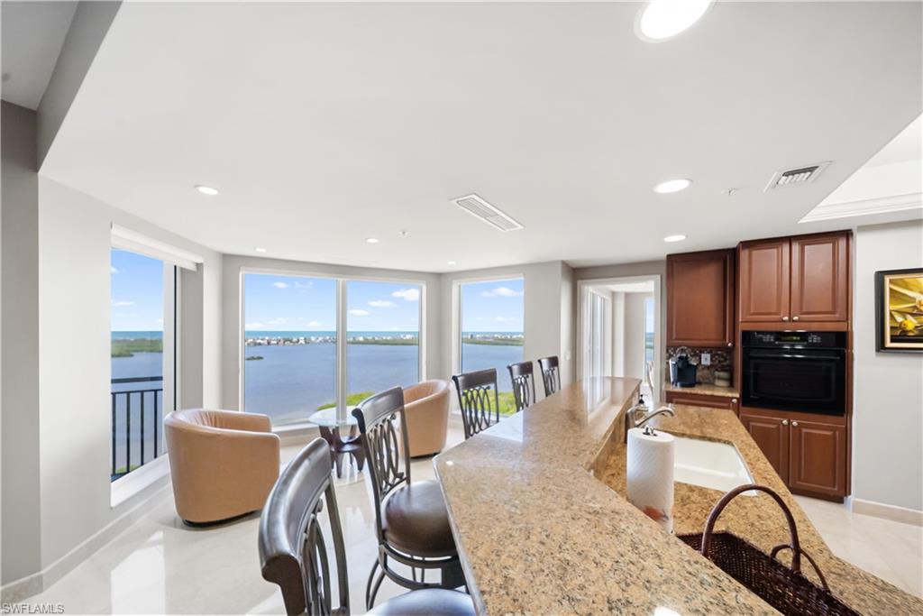 Expansive kitchen island with stone-finish countertop, undermount sink, and integrated breakfast bar