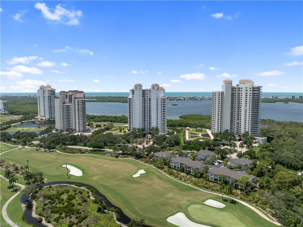 Coastal setting featuring residential towers, golf course, water bodies, and landscaping