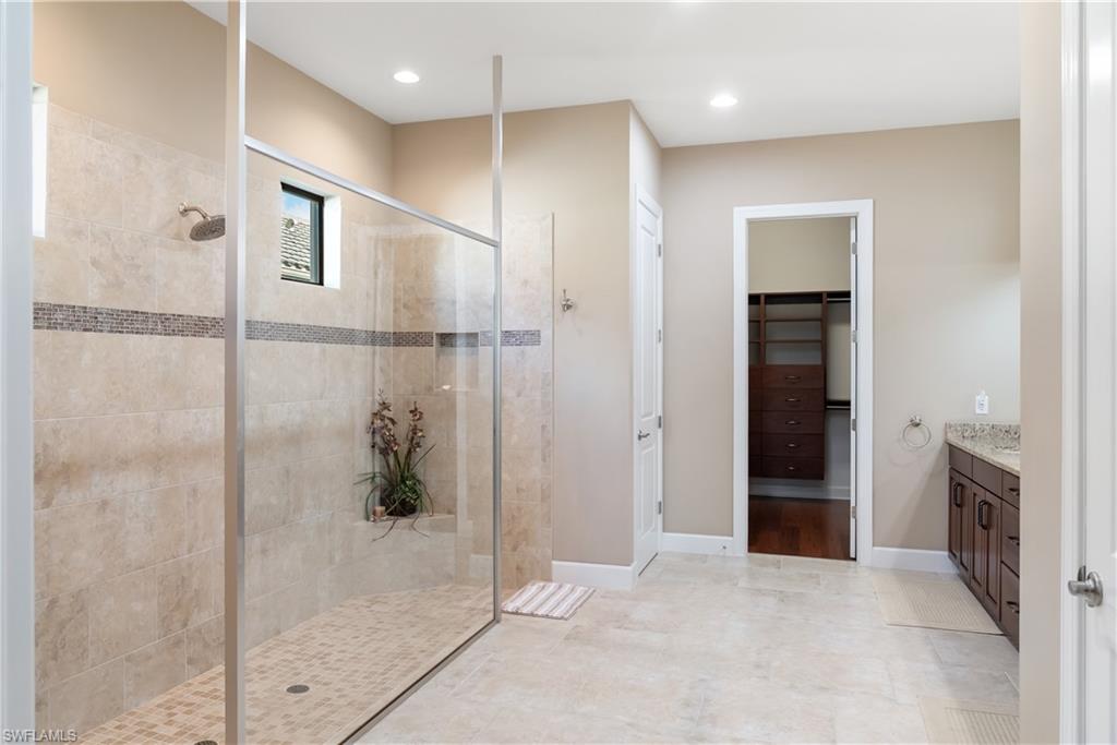 Spacious bathroom featuring a large walk-in shower with tile surround, glass enclosure, and a built-in niche