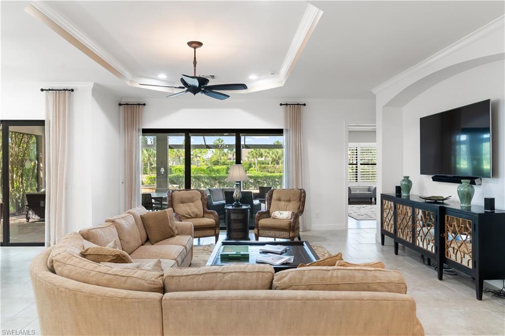 Tray ceiling with a ceiling fan, recessed lighting, and large sliding glass doors