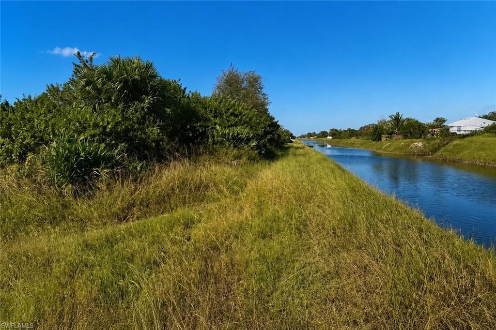 Canal access property with lush natural landscaping and distant residential structures