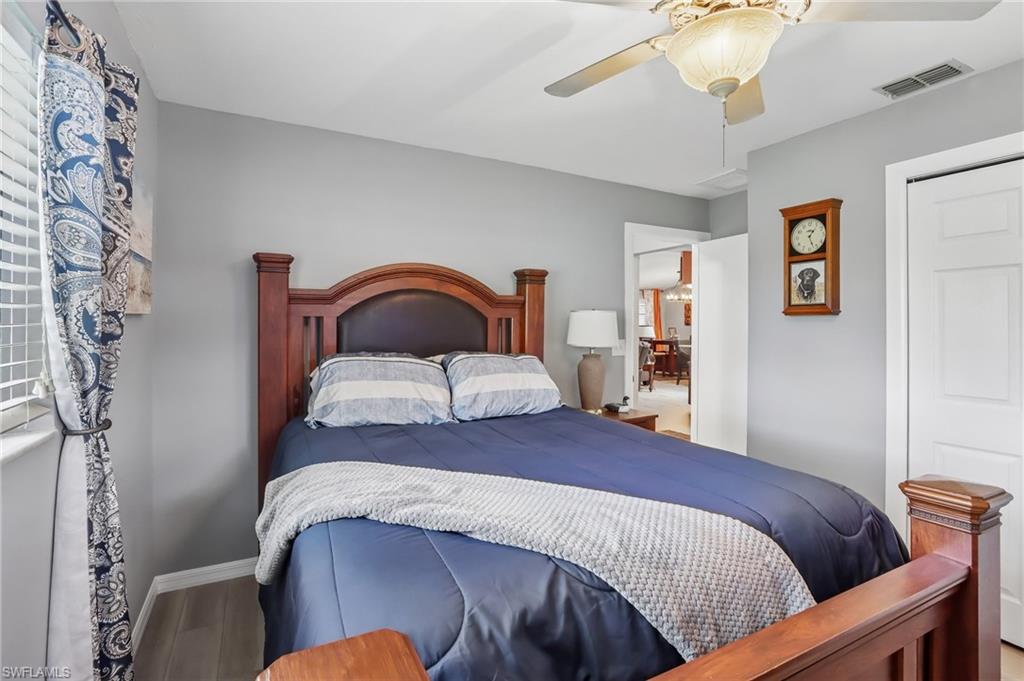 Wood-finish flooring, ceiling fan with integrated lighting, window blinds, and solid interior doors