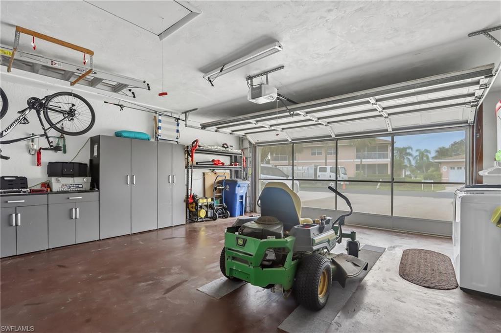 Garage space featuring built-in cabinetry, overhead storage, and an automatic garage door opener