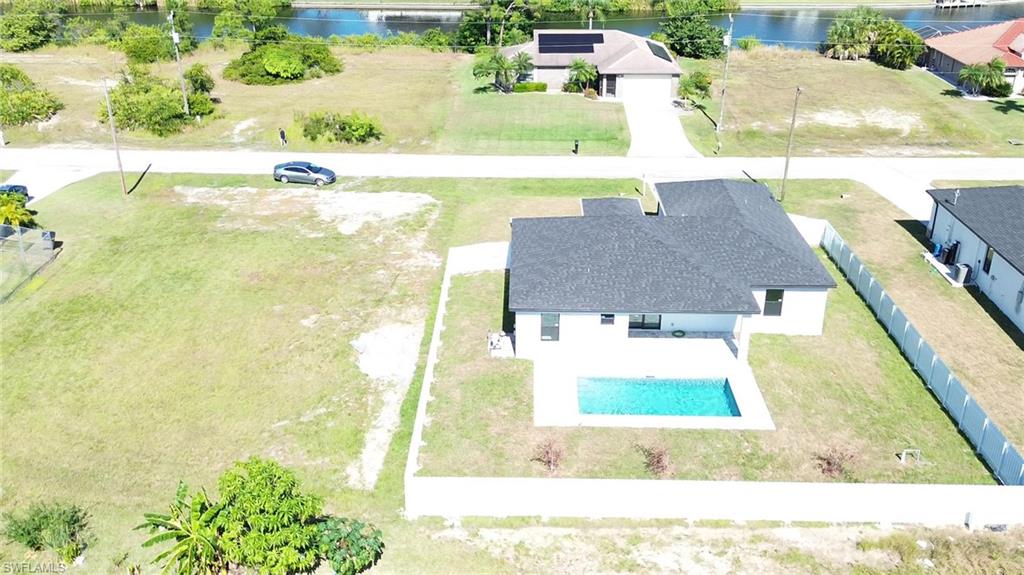 White exterior with dark roof and a rectangular pool