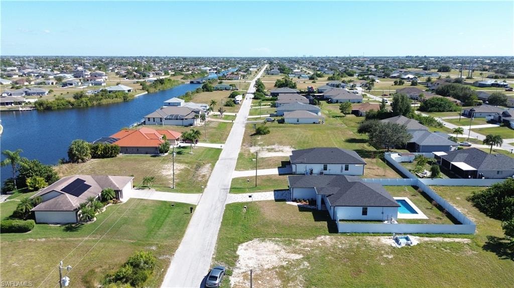 Waterfront property with a private pool, fenced yard, and a paved street
