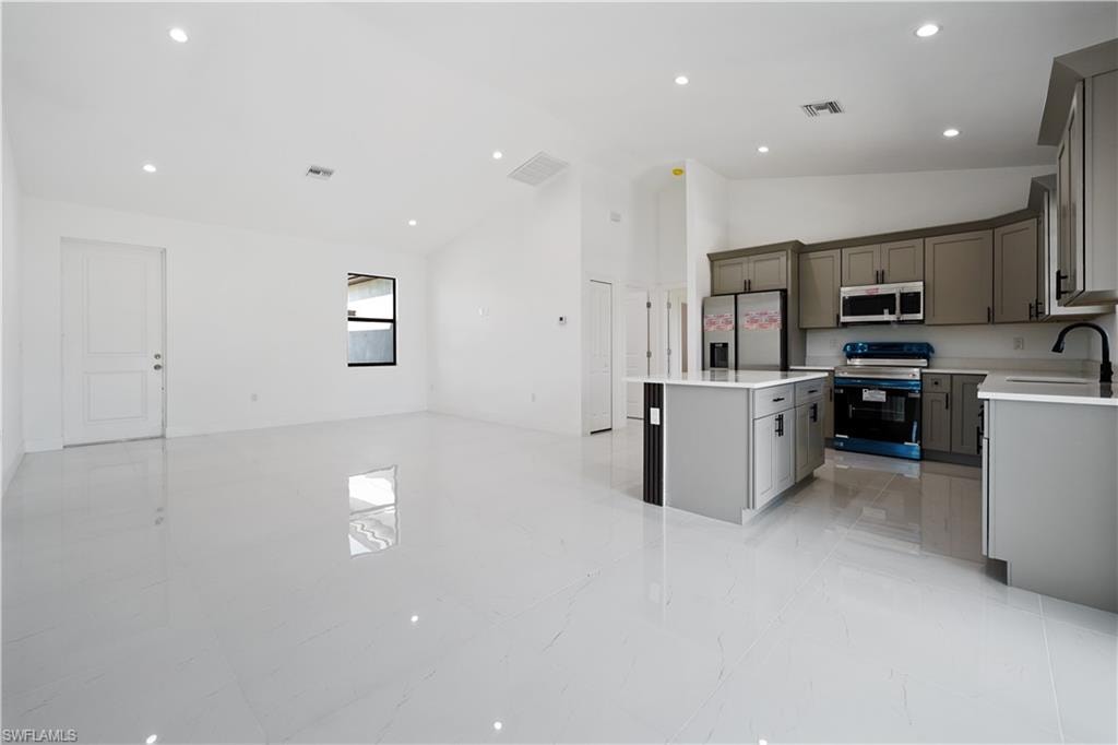 Open-concept living space featuring high ceilings, recessed lighting, and large format floor tiling