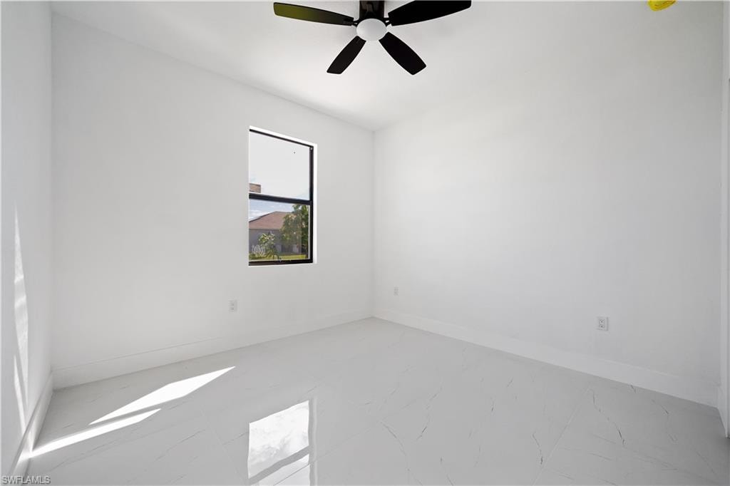 White interior walls, black ceiling fan, single window, white tiled flooring, ample natural light