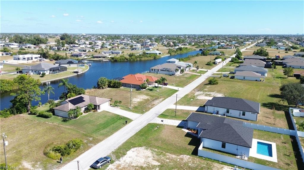 Canal-front property with solar panels, mature trees, and an expansive lawn