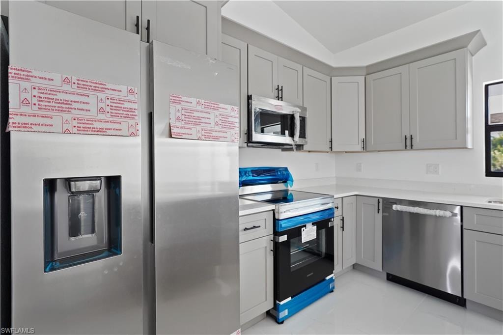 Kitchen featuring shaker-style cabinetry, white countertops, and stainless steel appliances