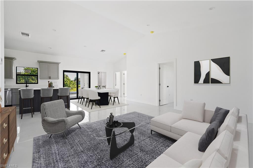 Vaulted ceilings, a kitchen island with seating, a window over the sink, an eat-in kitchen area, and sliding glass doors