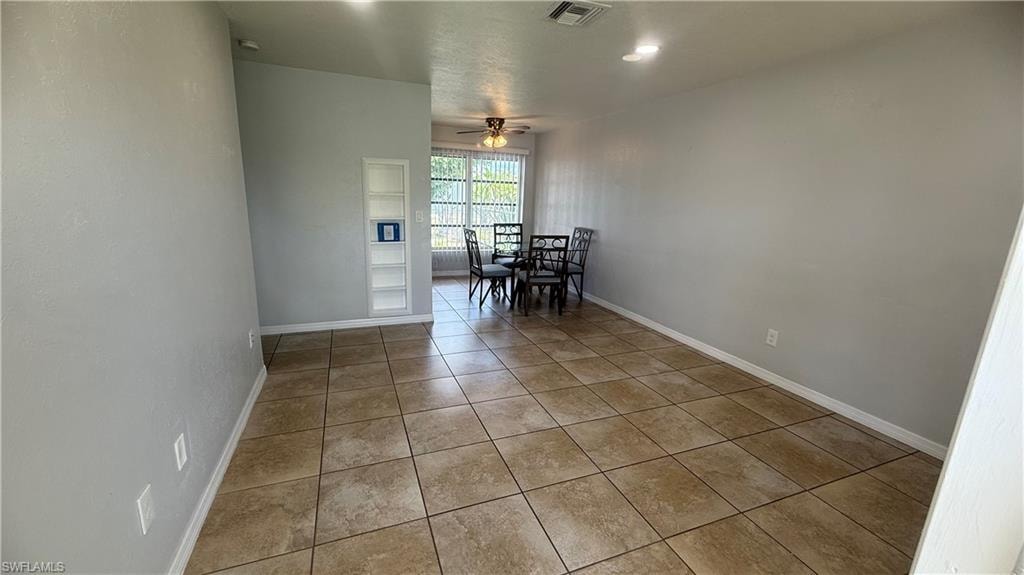 Tiled dining space featuring ceiling fan and recessed lighting