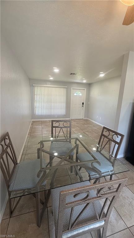 Dining space with a textured ceiling and light tile patterned flooring