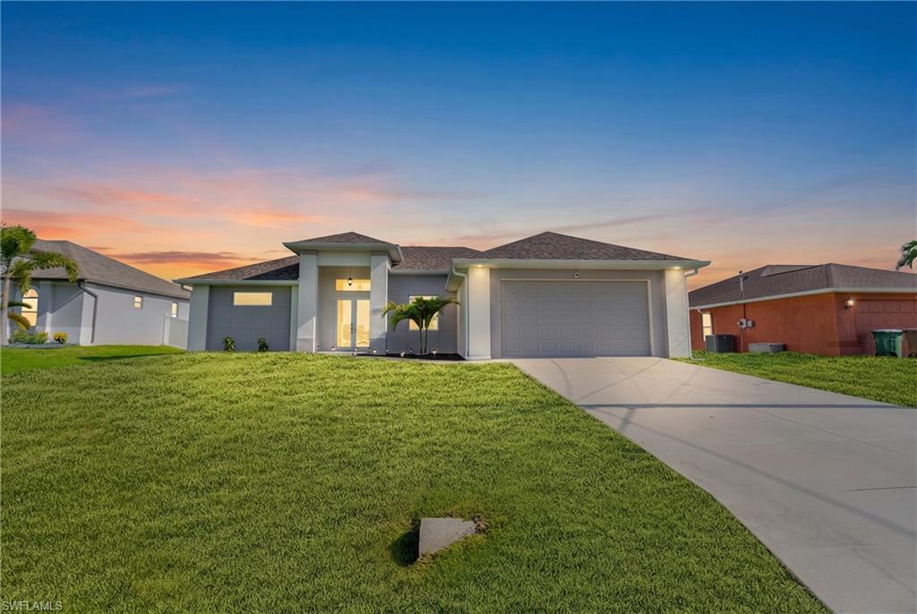 Contemporary-style residence featuring a prominent front entrance with double doors, an attached two-car garage, and a concrete driveway