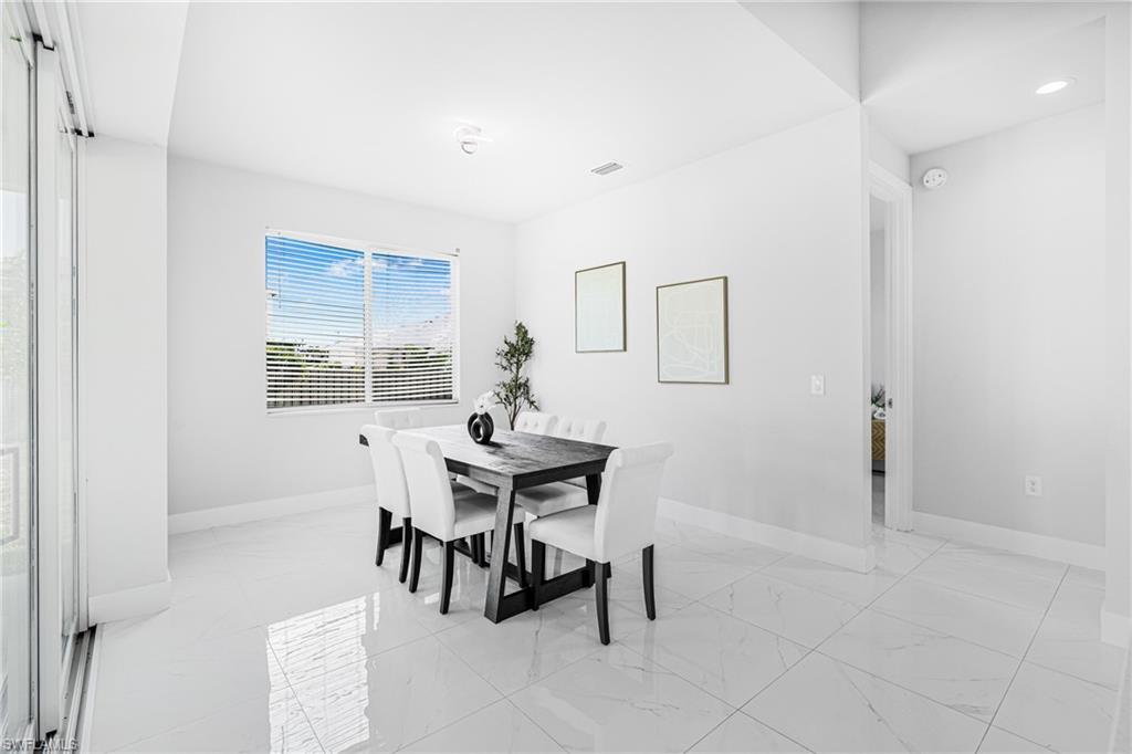 White tile flooring, recessed lighting, sliding glass door, window with horizontal blinds, and a doorway