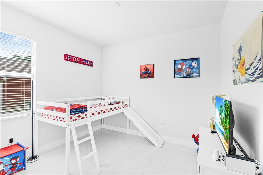 White walls, sleek white flooring, and a window with horizontal blinds