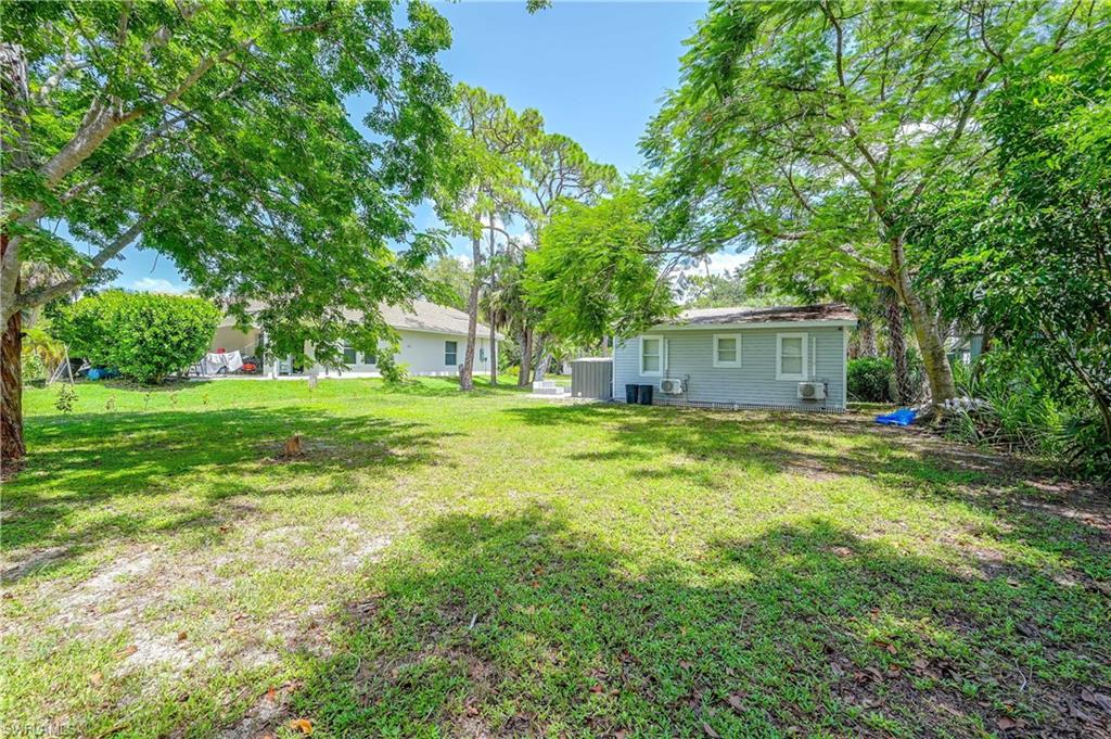 Expansive lawn area with mature trees providing natural shading