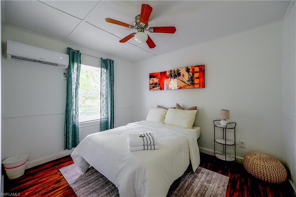 Wood-finish flooring, white walls, and a white ceiling with paneling