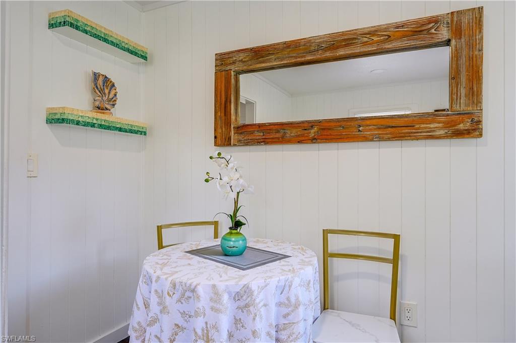 White beadboard walls complement a large rectangular mirror with a distressed wood frame