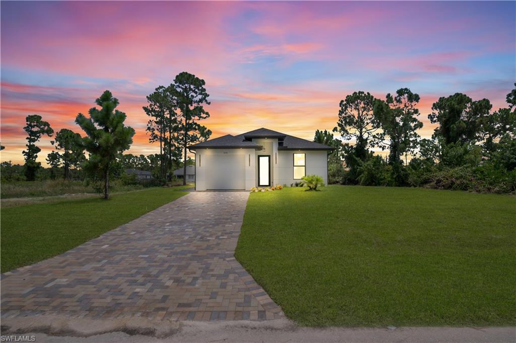 Contemporary single-story residence with a dark roof and light-colored exterior