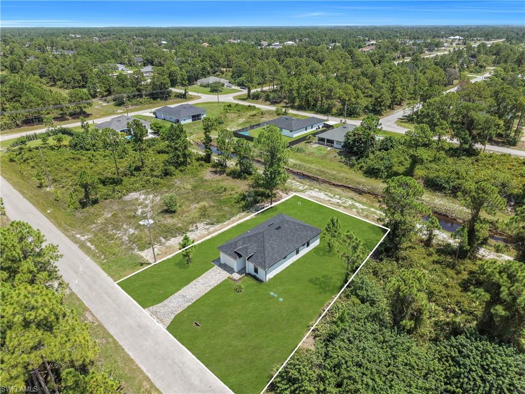 Contemporary single-story residence with a dark shingle roof, white exterior, and a stone-paver driveway