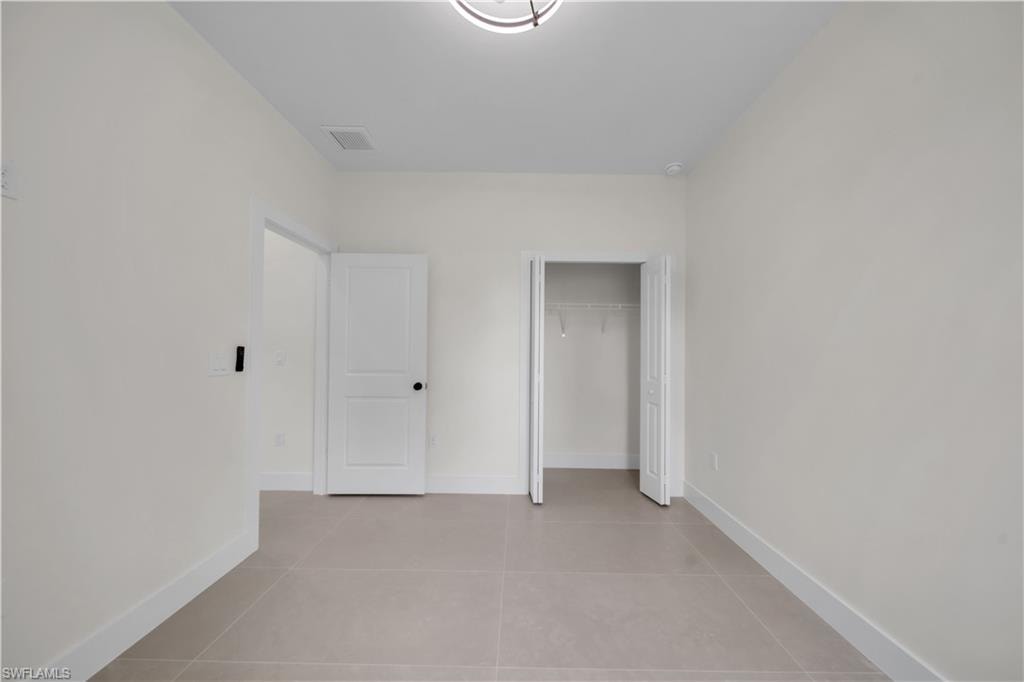 Recessed lighting, light-toned walls, tile flooring, and white interior doors