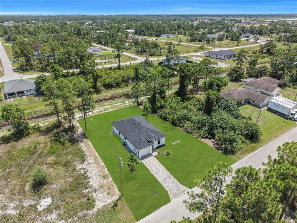 Single-story residence featuring a dark shingle roof and a green lawn