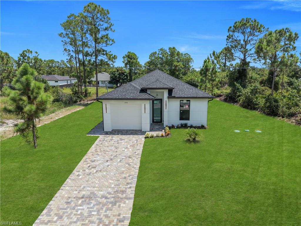 Modern exterior with a dark shingle roof, white stucco siding, and dark-framed windows