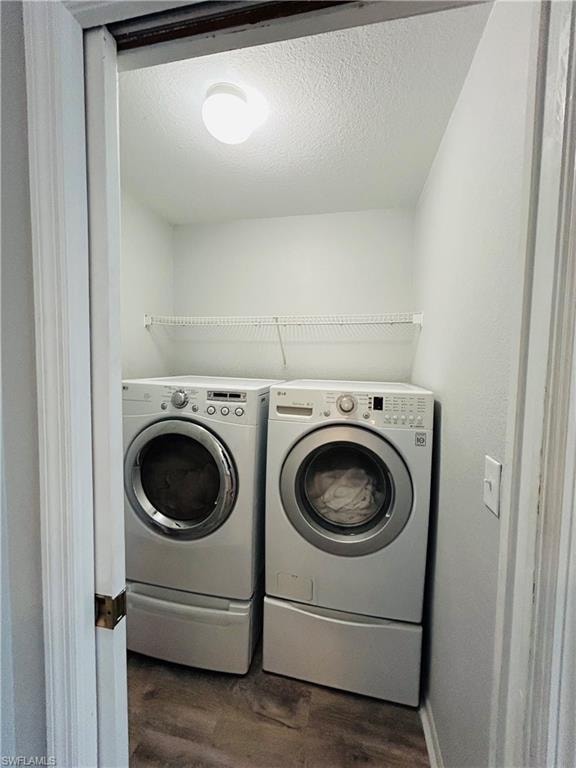 Dedicated laundry area featuring a front-loading washer and dryer, wire shelving, and wood-finish flooring