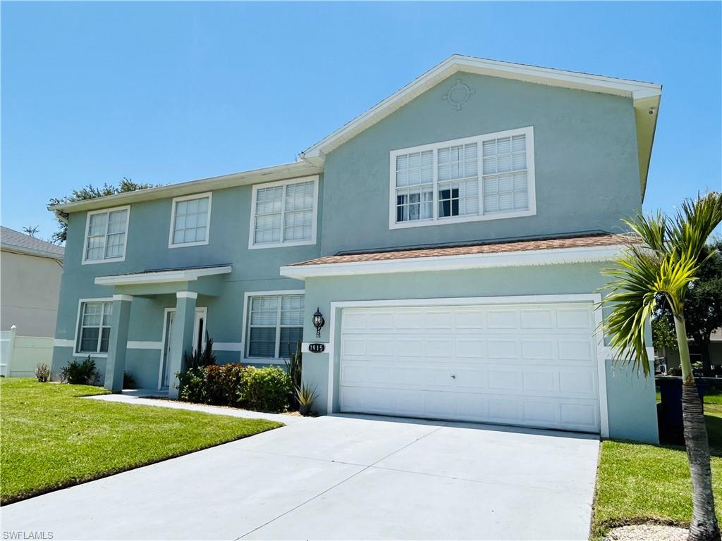 Two-story stucco exterior with white trim, covered entry, and an attached two-car garage