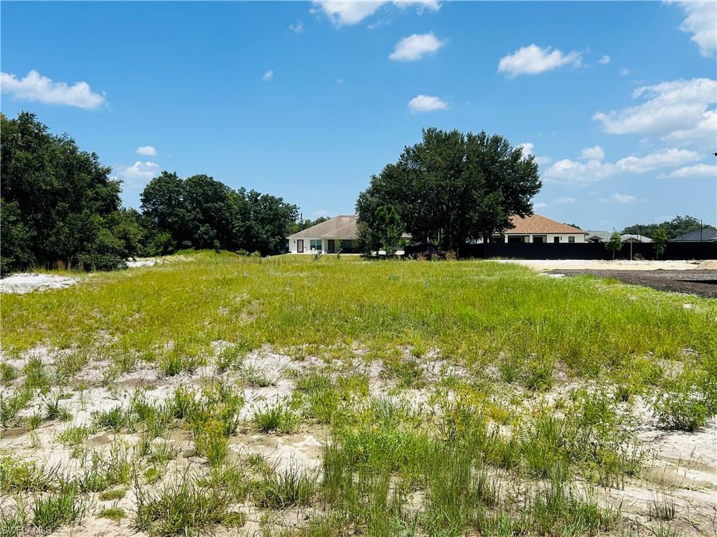 Expansive grounds with mature oak trees providing natural shade and privacy, complemented by lush landscaping and open acreage