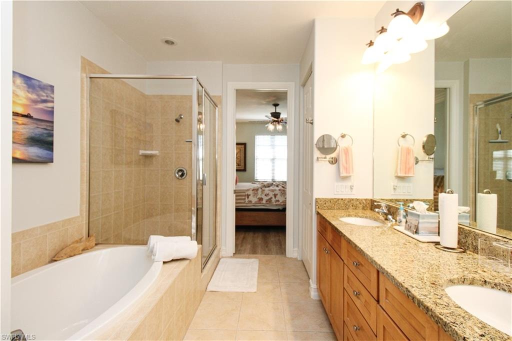 Bathroom with vanity, separate shower and tub, and tile patterned flooring