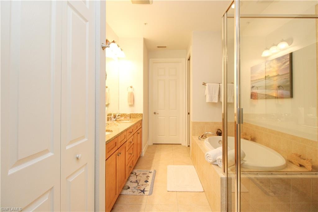 Bathroom featuring vanity, independent shower and bath, and tile patterned flooring