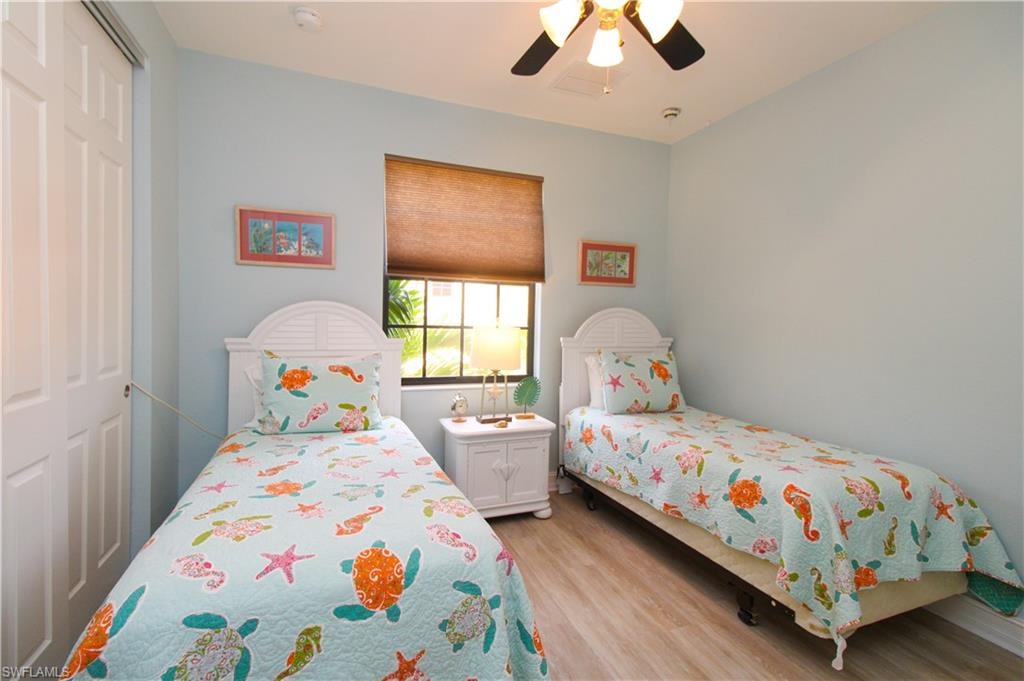 Bedroom with a closet, light wood-type flooring, and ceiling fan