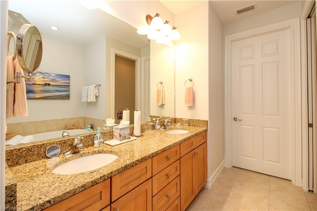 Bathroom featuring vanity, tile patterned flooring, and a bathing tub