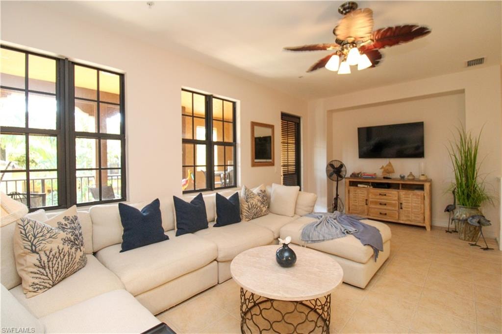 Living room featuring light tile patterned floors and ceiling fan