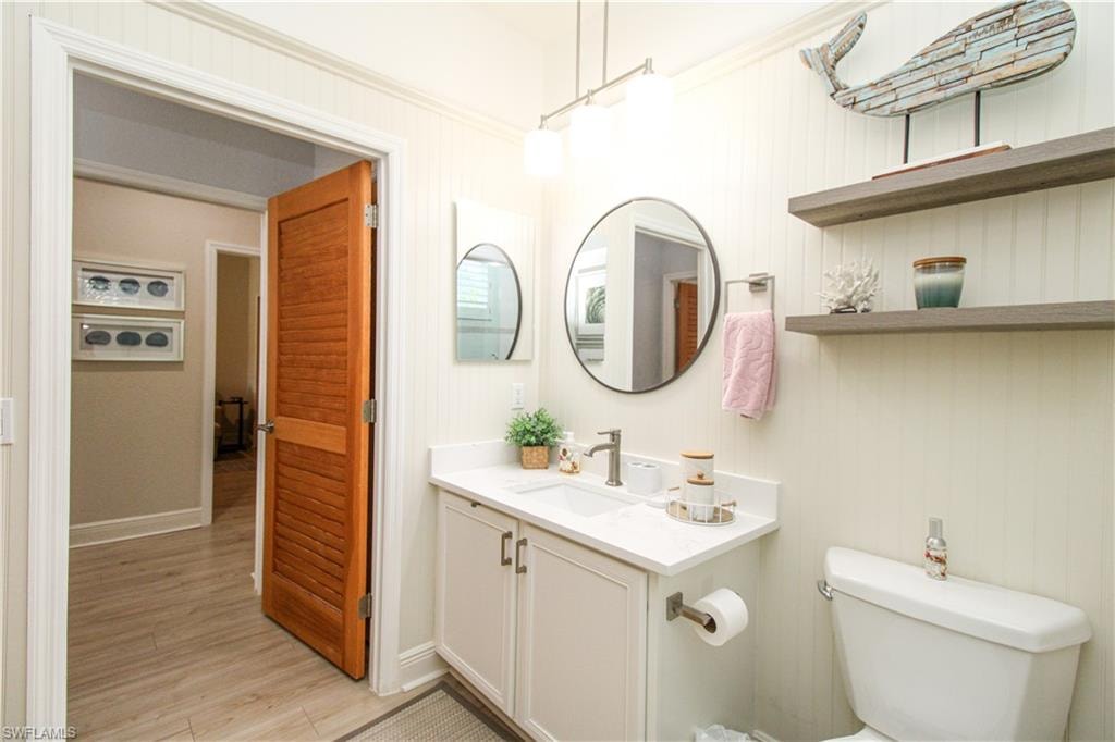 Bathroom with vanity, toilet, and hardwood / wood-style floors