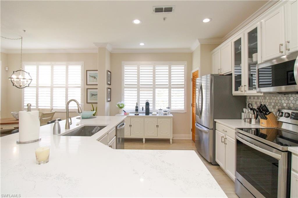 Kitchen with decorative backsplash, stainless steel appliances, sink, and plenty of natural light
