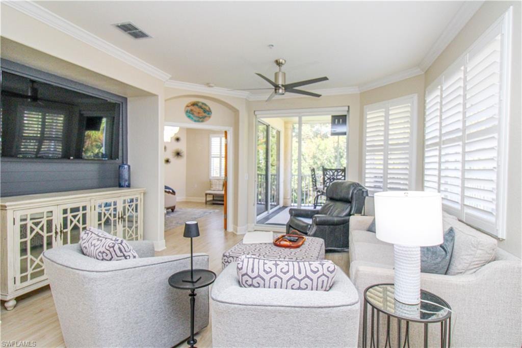 Living room featuring light hardwood / wood-style floors, crown molding, and ceiling fan