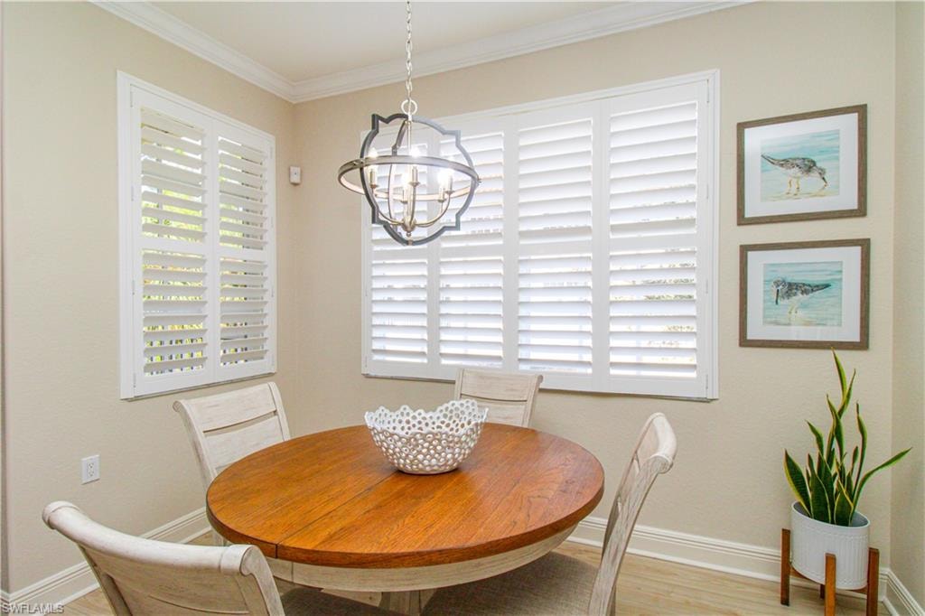 Dining space featuring crown molding, a chandelier, and light wood-type flooring