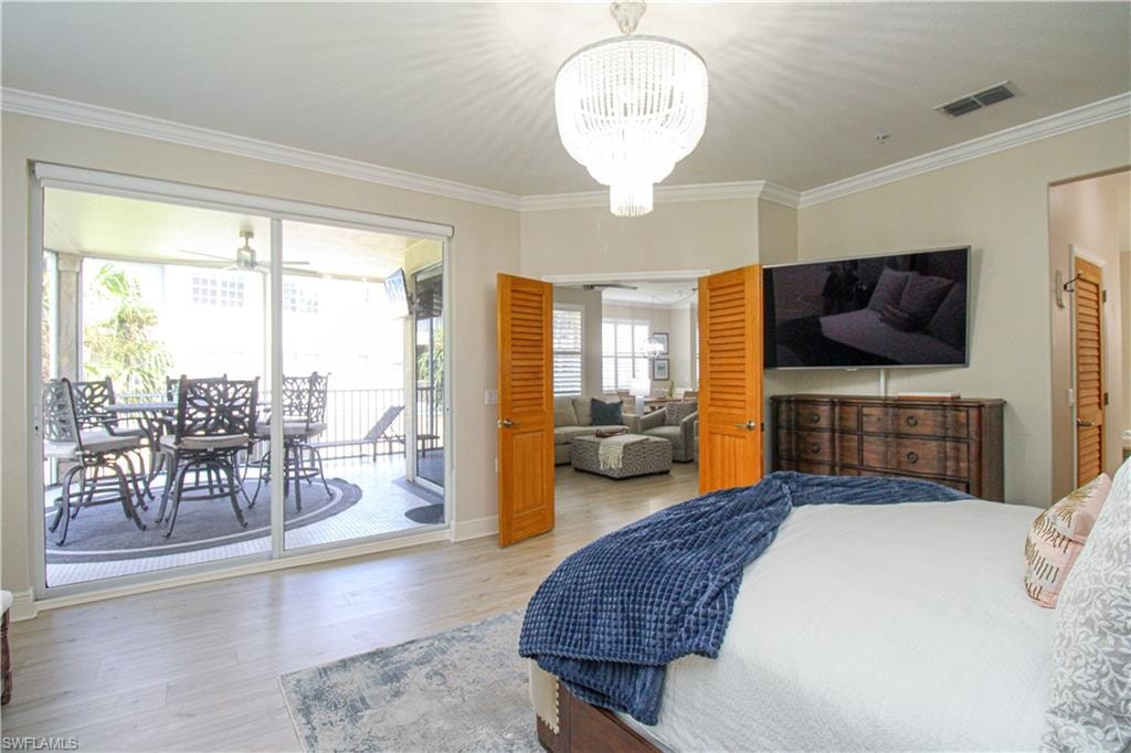 Bedroom with crown molding, access to outside, and wood-type flooring