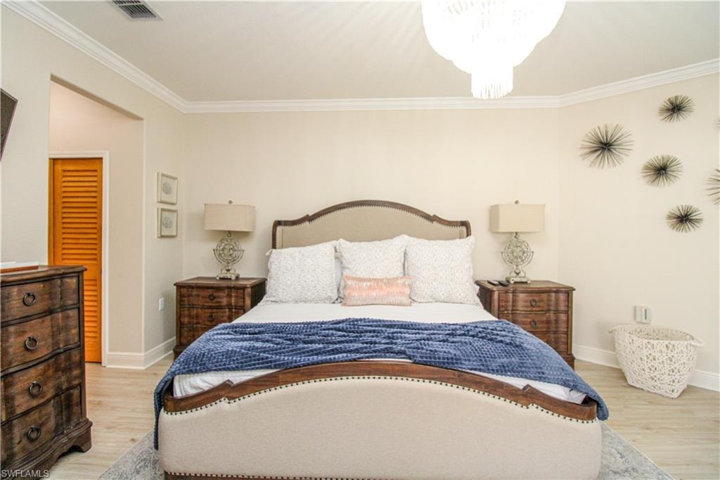 Bedroom featuring light hardwood / wood-style flooring and crown molding