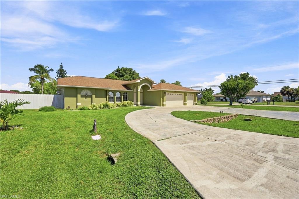Symmetrical facade with arched entryways, dual garage doors, and a curved concrete driveway