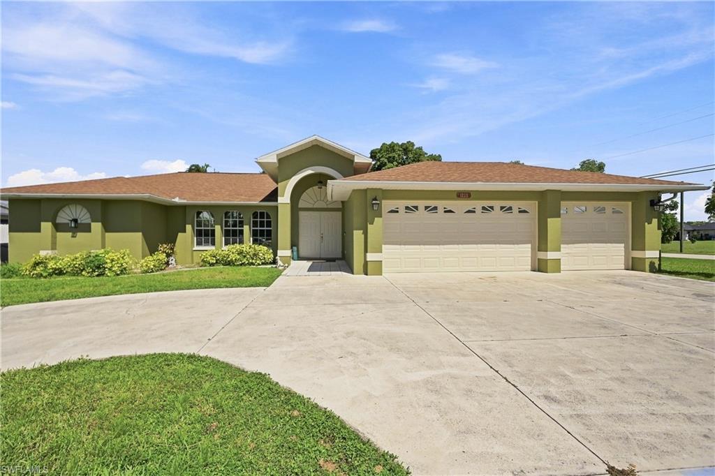 Single-story residence featuring a painted exterior finish, arched entry, multiple arched windows, and a multi-car garage