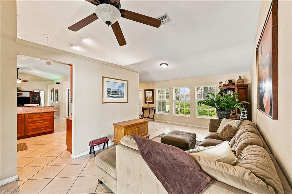 Spacious living area featuring a ceiling fan, recessed lighting, and multiple windows