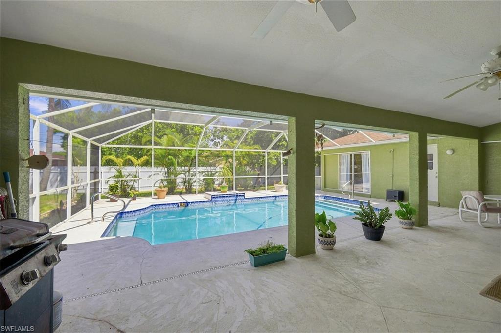 Screened-in pool deck featuring a swimming pool, concrete patio, and overhead ceiling fans