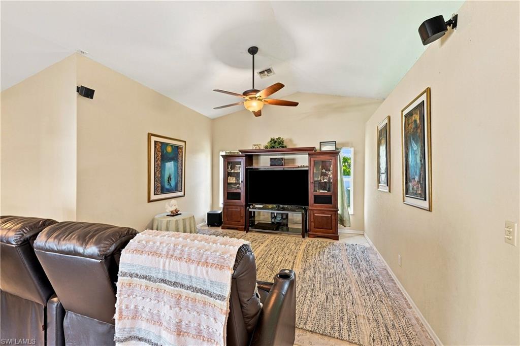 Vaulted ceiling with a ceiling fan, wall-mounted speakers, and a large media console with built-in cabinetry